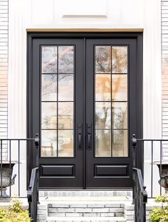 two black double doors on the front of a house