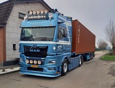 a blue truck is parked in front of a building