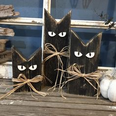 two black wooden cats with eyes tied to each other