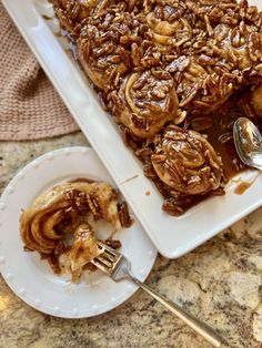 a white plate topped with dessert covered in caramel swirls next to a fork