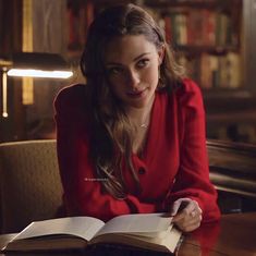 a woman sitting at a table with an open book