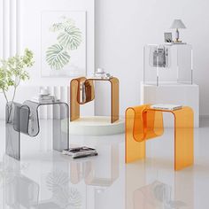 an assortment of modern glass and metal furniture in a white room with plants on the table