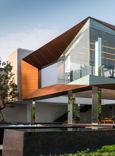 a modern house with an unusual roof and glass walls