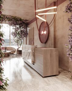 an elegant reception area with pink flowers on the wall and marble countertop, along with hanging planters