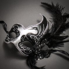 This Masquerade Side Feather Glitter Venetian Costume Prom Mask is the epitome of elegance and style. The silver and purple color, while the glitter adds a touch of glamour. The side feathers add a touch of drama, making this mask the perfect choice for any masquerade ball, Venetian-themed event, or prom. Whether you're looking to add a touch of mystery to your look or simply want to make a statement, this Masquerade Side Feather Glitter Venetian Costume Prom Mask is the perfect choice. The mask is easy to wear, with a secure and comfortable fit, making it ideal for a night of dancing and revelry.   Product Description: Made from a plastic base and hand-crafted feathers, glitter, and flower.  This mask fits most adults Comes with ribbons on 2 sides to wear or an elastic strap to keep the m Halloween Party Music, Prom Mask, Venetian Costumes, Venetian Costume, Jester Mask, Mardi Gras Masks, Mask Carnival, Luxury Mask, Mens Masquerade Mask