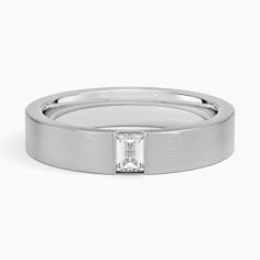 a white gold ring with a baguette cut diamond in the center and a thin band