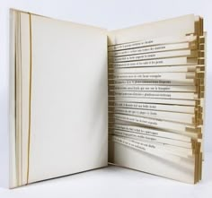 an open book with several pencils sticking out of it