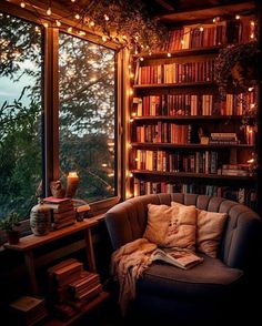 a couch in front of a window with bookshelves filled with books and lights