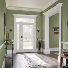 an entryway with wooden floors and gray walls