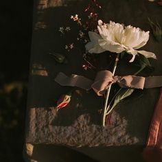 flowers are placed on top of a piece of cloth with ribbon around it and tied together