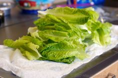 some lettuce is sitting on top of a paper towel in the middle of a kitchen counter