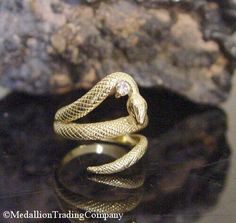 Designer 18k Yellow Gold Coiled Serpent Snake Diamond Bypass Wrap Ring Size 6 Medallion Trading Company   14K YELLOW GOLD  SNAKE RING WITH A DIAMOND- SIZE 6   Condition: Good vintage condition. Professionally cleaned and polished Weight: 5.74 grams Size: 6 Measurements: The ring is approximately .75 inches high (north to south) but it is flexible enough that it could be adjusted Markings: k18 Gemstones: (1) natural round cut diamon Unique Gold Snake Ring For Formal Events, Unique Gold Snake Ring For Formal Occasions, Gold Snake Ring Collectible Unique Style, Antique Gold Snake-shaped Jewelry, Gold Snake-shaped Ring For Anniversary, Unique Gold Snake Ring Collectible, Antique Snake-shaped Yellow Gold Jewelry, Hallmarked Yellow Gold Snake Ring For Anniversary, Antique 14k Gold Snake Ring For Anniversary