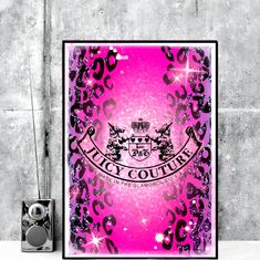 a pink and black poster with the words juicy couture on it next to speakers