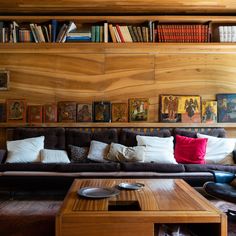 a living room filled with lots of furniture next to a book shelf full of books