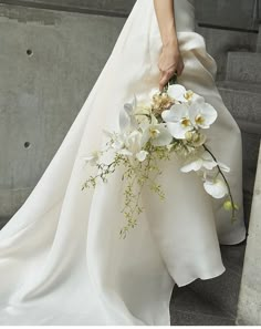 a woman in a wedding dress holding a bouquet of flowers