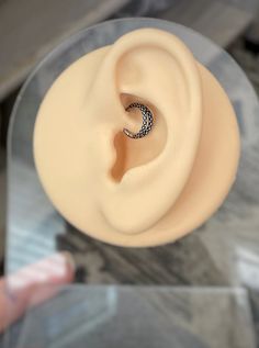 a close up of a person's hand holding a fake ear