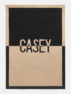 a black and beige scarf with the word casey printed on it