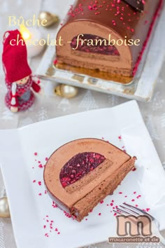 a piece of chocolate cake on a white plate with red sprinkles next to it