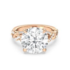 a rose gold engagement ring with a round diamond in the center and two small diamonds on each side