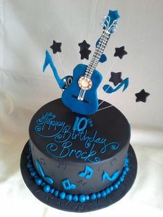 a blue and black birthday cake with a guitar on top