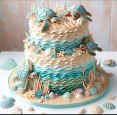 there is a cake decorated with shells and sea animals on the top tier, along with seashells