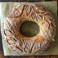 a piece of bread that has been carved into the shape of a circle with leaves on it