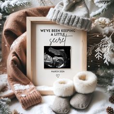 there is a picture frame and two baby shoes on the ground next to a christmas tree