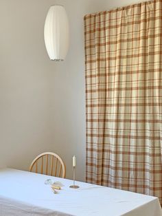 a dining room with a white table and brown checkered curtains