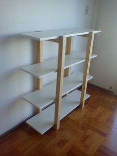 a white book shelf sitting on top of a hard wood floor