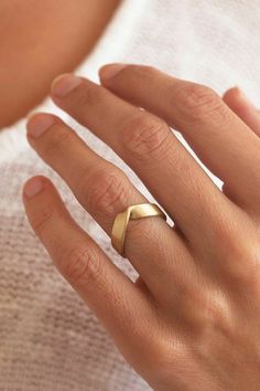 a woman's hand with a gold ring on it