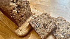 three loaves of bread sitting on a cutting board next to a loaf of bread