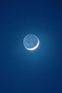 the moon is shining brightly in the blue sky with no clouds on it's side