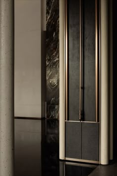 a tall black and gold clock sitting in the middle of a room with marble walls