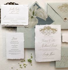 the wedding stationery is laid out on top of each other, including two envelopes