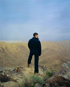 a man standing on top of a rocky hill