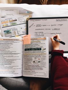 a person sitting on a couch with papers and a pen in their hand