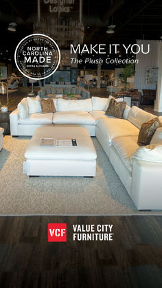 a living room with white couches and pillows on the floor in front of a sign that says make it you