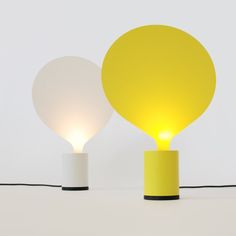 two yellow and white lamps sitting next to each other