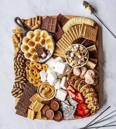 a platter filled with different types of snacks and desserts on top of a marble table