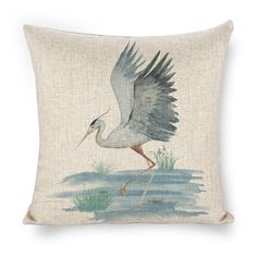 a pillow with a bird on it and grass in the water, as well as an image of a crane