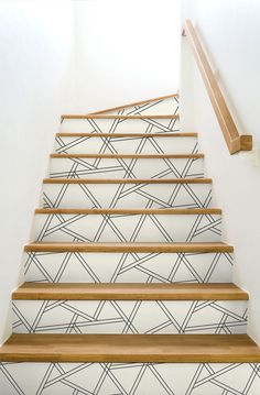 the stairs are painted with black and white geometric designs on them, as well as wood handrails