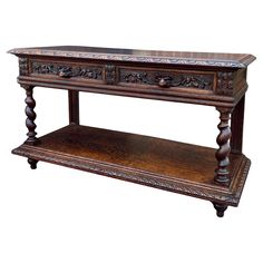 an ornate wooden table with two drawers on one side and a shelf on the other