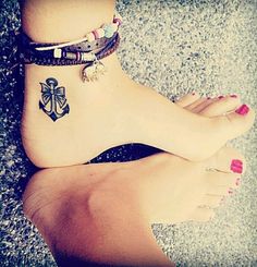 a woman's foot with a tattoo on it and two bracelets around her ankles