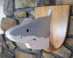 a shark shaped toothbrush holder on a stone wall