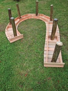 a wooden bridge made out of logs in the grass