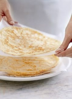 a person is placing tortillas on top of each other to serve them for lunch