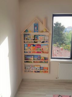 a child's playroom with bookshelves and toys on the floor in front of a window