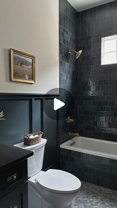 a bathroom with black tile and white fixtures