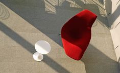 an overhead view of a red chair and two white plates on the floor next to each other