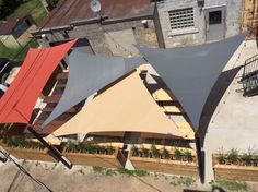 an aerial view of a building with several different colored awnings on the roof